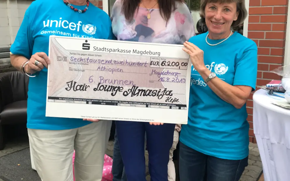 Almasija Hess überreicht den Scheck an Paula Knocke (links) und Sabine Koch, beide Unicef AG Magdeburg Bild der Scheckübergabe
