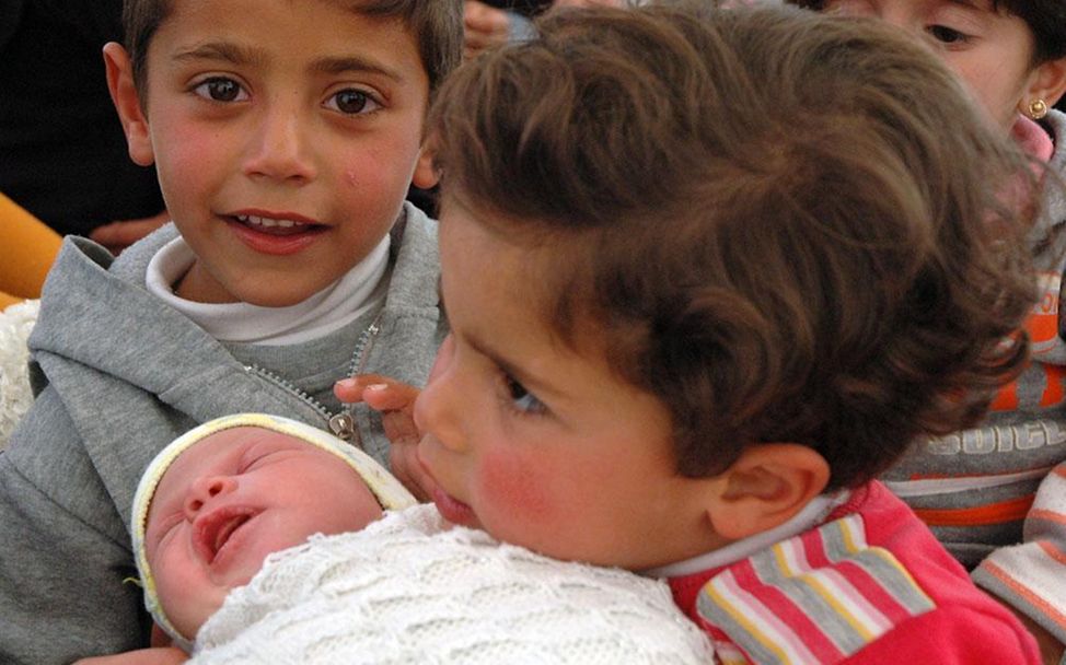 Za'atari-Camp/Jordanien: Maya, 13 Tage alt, mit ihren Geschwistern (© UNICEF/2013/Schneider)