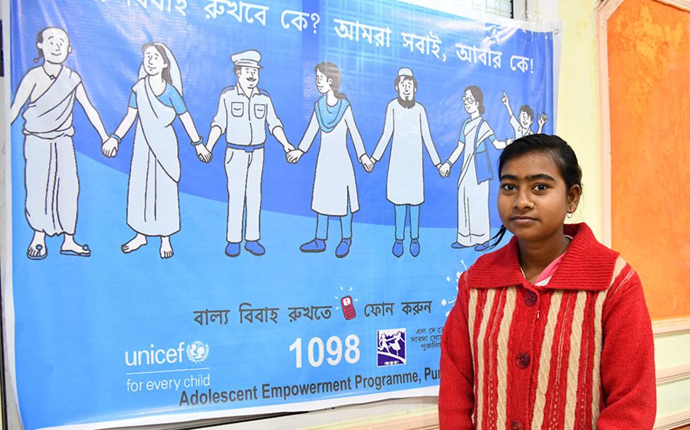 Indien: Die 16-jährige Maina steht vor einem UNICEF-Plakat.