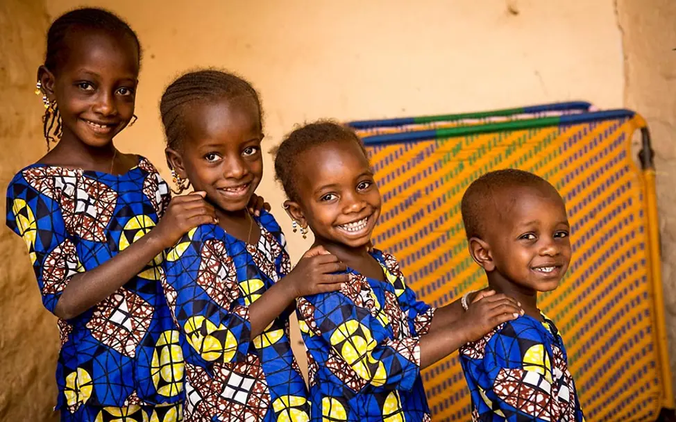 Den Schwestern konnte im Gesundheitszentrum schnell geholfen werden. | © UNICEF/Keïta Sterblichkeit unter Säuglingen und Kindern verbessern: Vier Schwestern in Mali stehen lachend hintereinander.