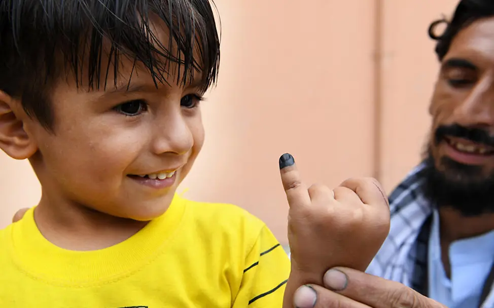Impfungen schützen Kinder vor lebensgefährlichen Krankheiten. | © UNICEF/Frank Dejongh Kindersterblichkeit gesunken: Ein Junge zeigt nach der Impfung seine Fingermarkierung.