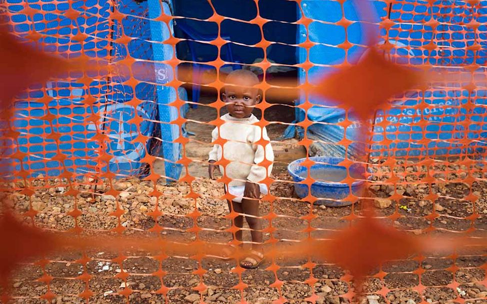 Ansteckungsgefahr Ebola: Ein Kleinkind steht hinter einer Absperrung einer Ebola-Sonder-Isolierstation.