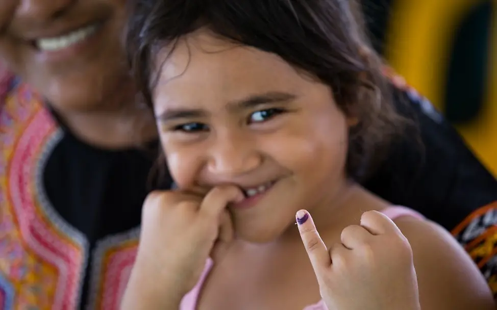 Joanne Sanele (5) aus Samoa im Dezember 2019. | © UNICEF/Stephen Samoa 2019: Ein Mädchen zeigt nach der Impfung ihren markierten Finger.