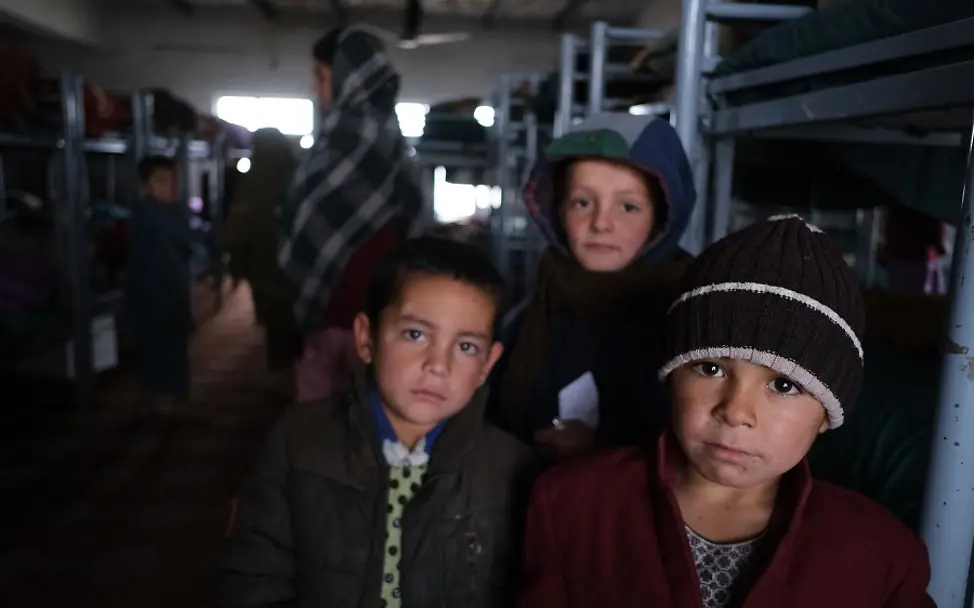 In einem Waisenhaus in Afghanistan. | © UNICEF/Bouvet Afghanistan: Drei Jungen stehen in einem dunklen Schlafsaal eines Waisenhauses.