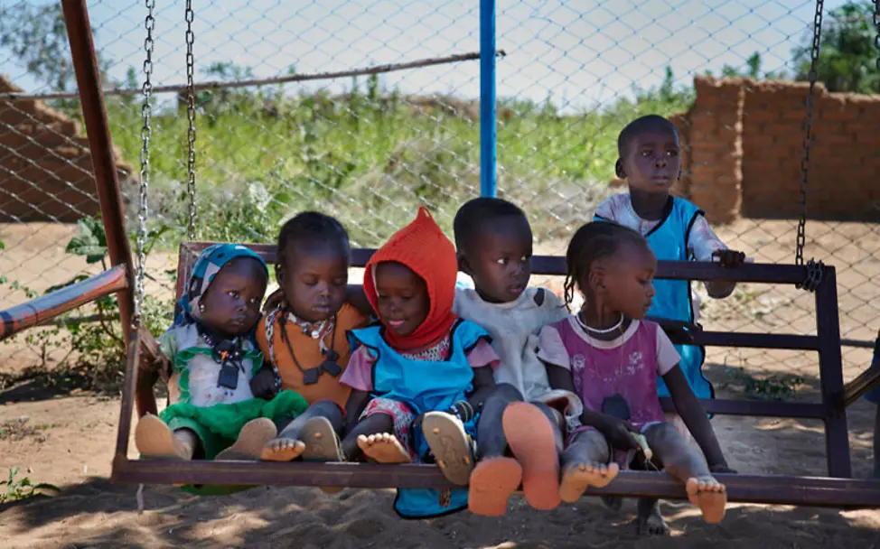Sudan: Kinder sitzen auf einer Schaukel | © UNICEF/Noorani Sudan: Kinder sitzen auf einer Schaukel