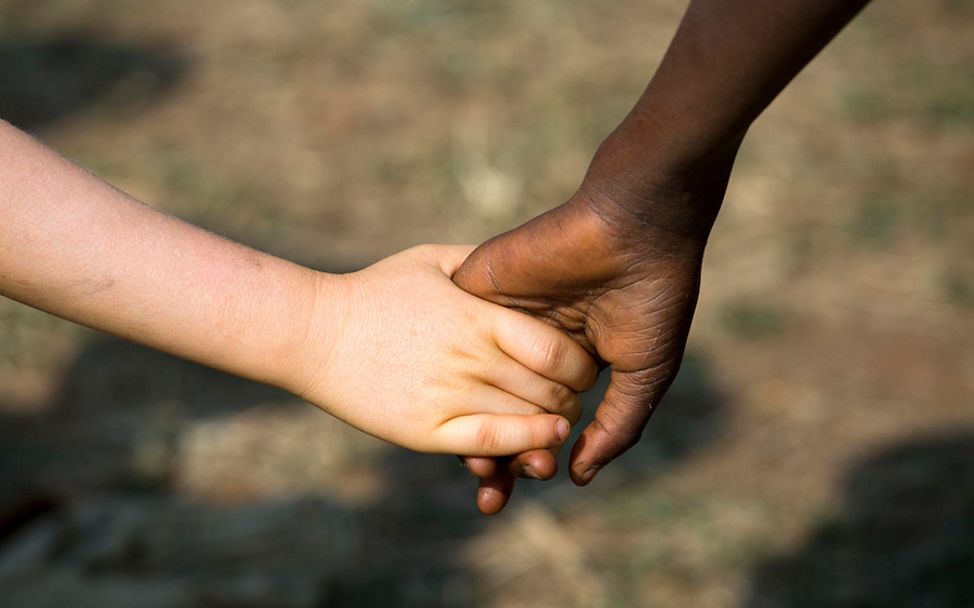 Burundi: Zwei Kinder halten sich beim Spielen an der Hand.