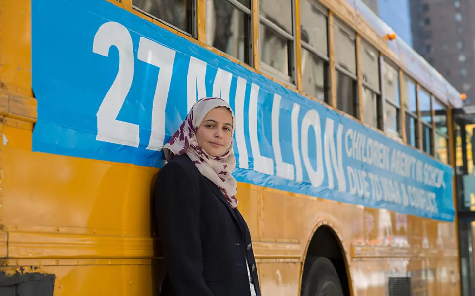 Muzoon weiß, Bildung ist nicht für alle zugänglich. | © UNICEF/Pietrasik New York: Muzoon vor einem der leeren Schulbusse der Aktion 27 Million.
