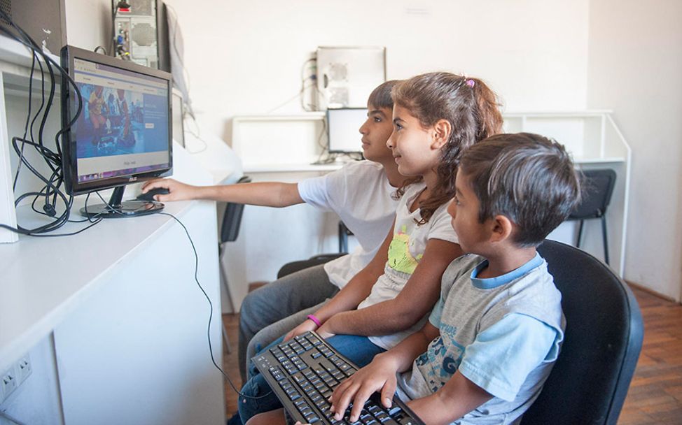 Belgrad: Drei Kinder durchstöbern das Internet in einem UNICEF-Zentrum.