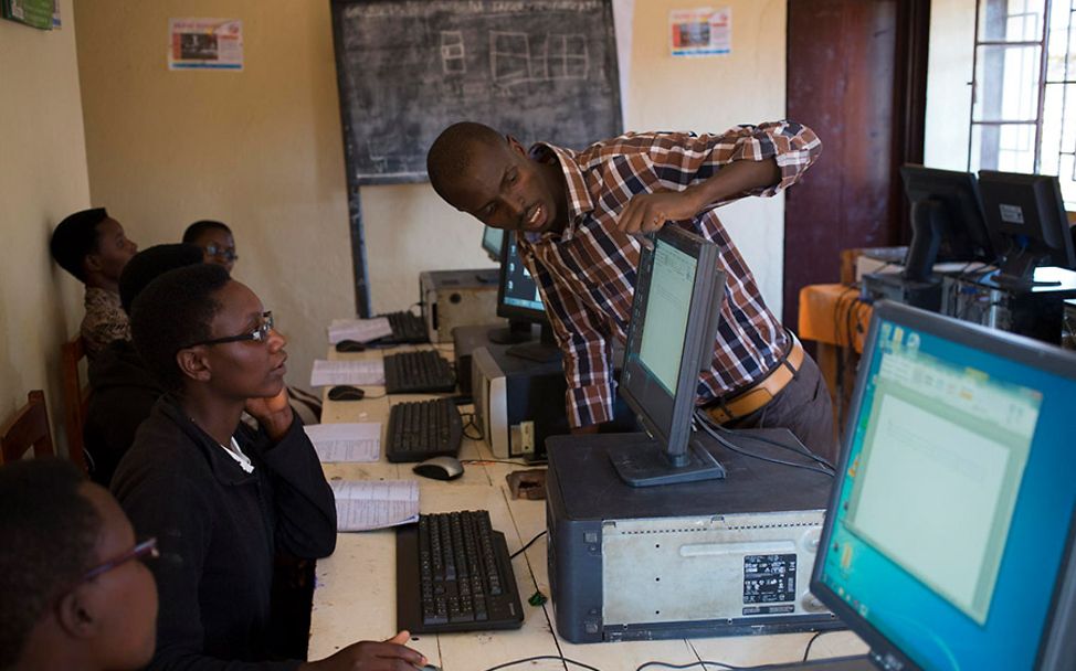 Burundi: Diodeme zeigt einer Kursteilnehmerin etwas an ihrem Computer.