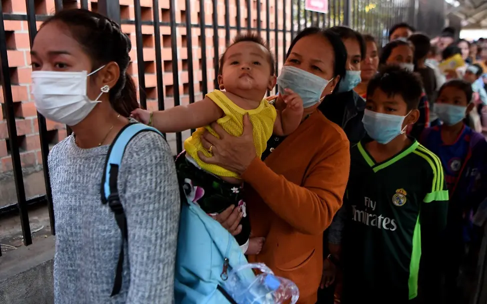 Auch in Kambodscha gibt es Menschen, die an dem Coronavirus erkrankt sind. | © UNICEF/UNI288092/Chhin Sothy/AFP-Services Kambodscha: Menschen mit Gesichtsmasken warten in einer Schlange.
