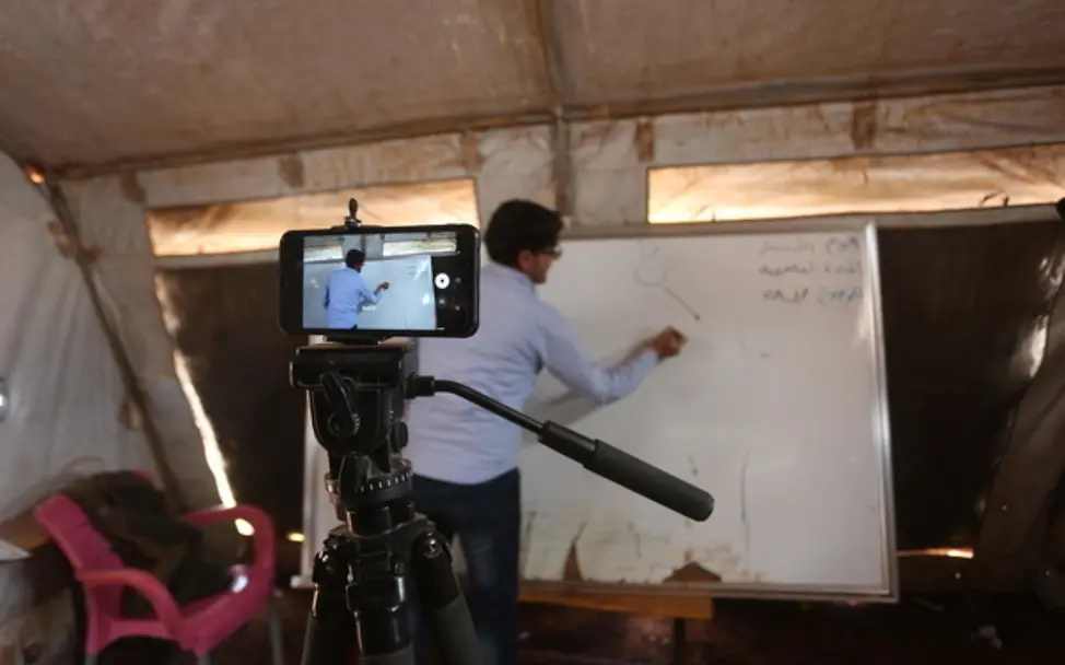 Ein Lehrer in Syrien nimmt ein Handyvideo auf. | © UNICEF/Suleiman Ein Lehrer in Syrien nimmt ein Handyvideo auf.