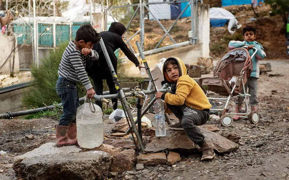 Zugang zu sauberem Wasser kann Leben retten. | © UNICEF/Romenz Griechenland: Kinder eines Flüchtlingslagers füllen ihre Wasserkanister auf.