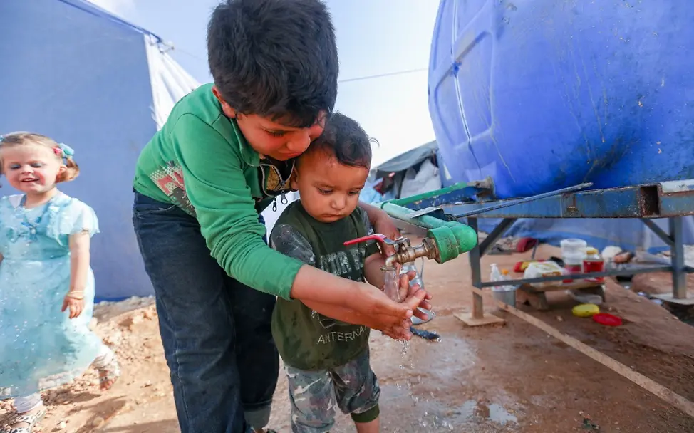 Syrien: Im Flüchtlingslager Maarat Misrin waschen sich zwei Jungen die Hände. | © UNICEF/Albam Syrien: Zwei Jungen waschen sich die Hände in einem Flüchtlingslager.