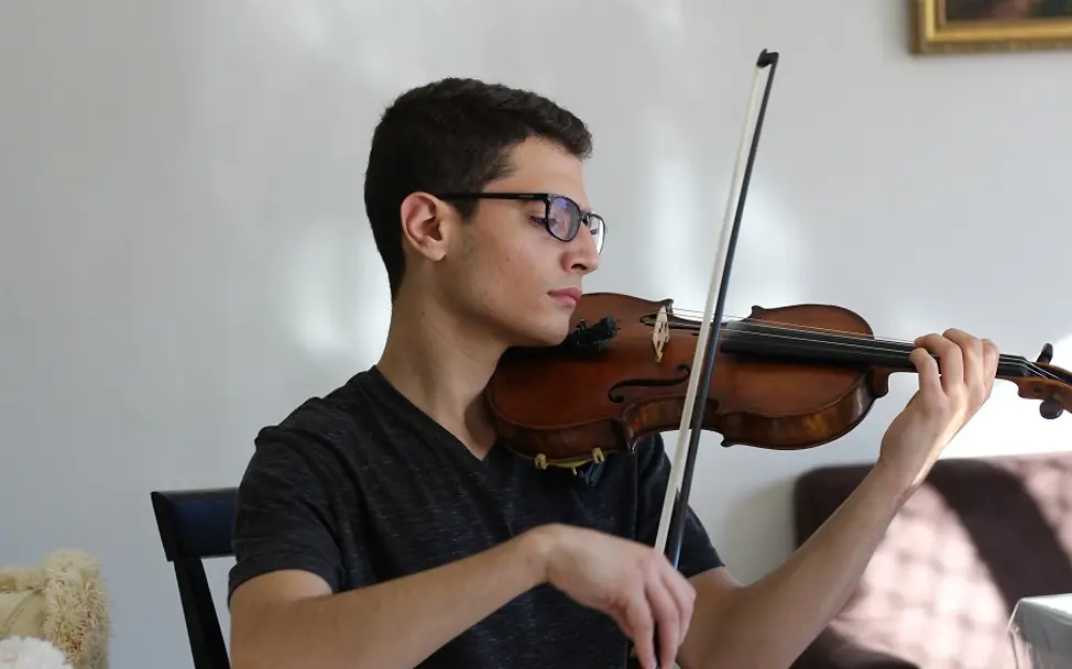 Der junge Syrer Aboud spielt konzentriert auf seiner Geige. | © UNICEF/Ziaziaris Australien: Der junge Syrer Aboud spielt auf seiner Geige.