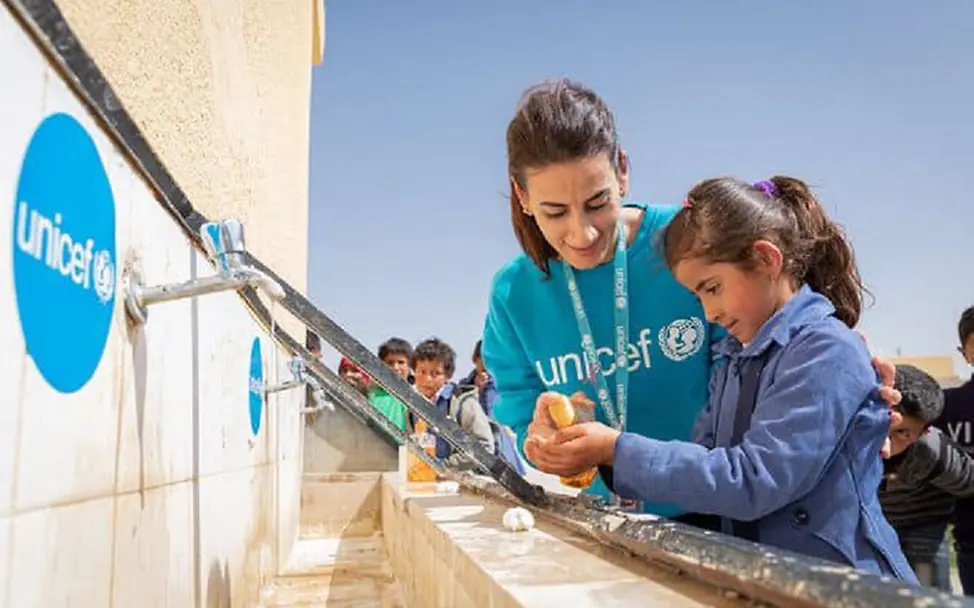 Eine UNICEF-Helferin hilft einem Mädchen beim Händewaschen. © UNICEF/UNI313299/Matas Eine UNICEF-Helferin hilft einem Mädchen beim Händewaschen. © UNICEF/UNI313299/Matas