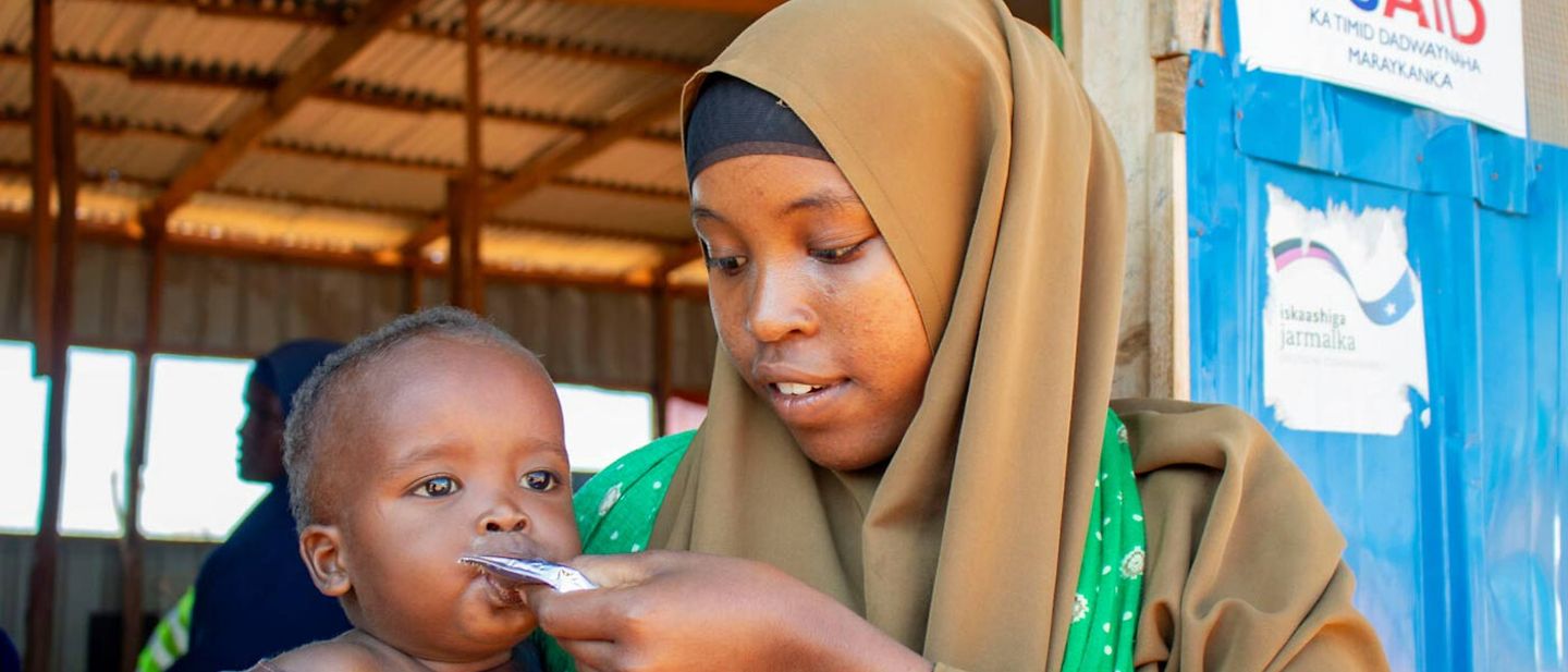 El Niño in Somalia: Eine Mutter füttert ihr Baby mit Erdnusspaste