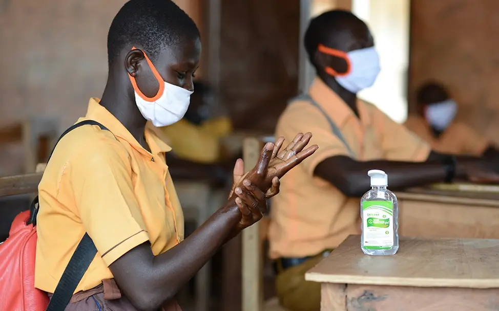 Handhygiene ist eine wichtige Maßnahme gegen Covid-19. | © UNICEF/UNI357812/Buta Schüler aus Ghana trägt Schutzmaske und desinfiziert sich die Hände.