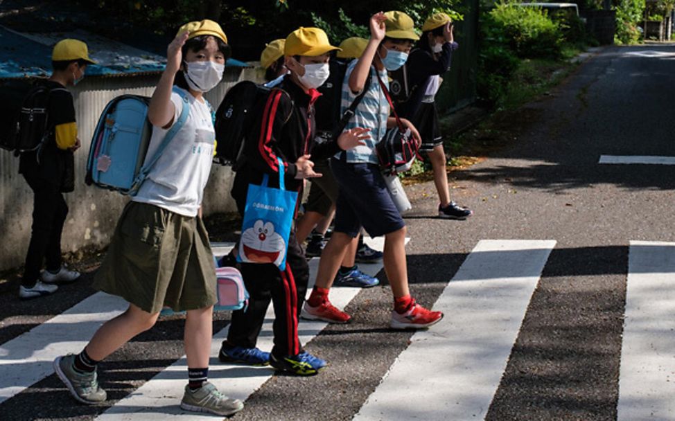 Schule während Corona: Schüler in Japan gehen über einen Zebrastreifen