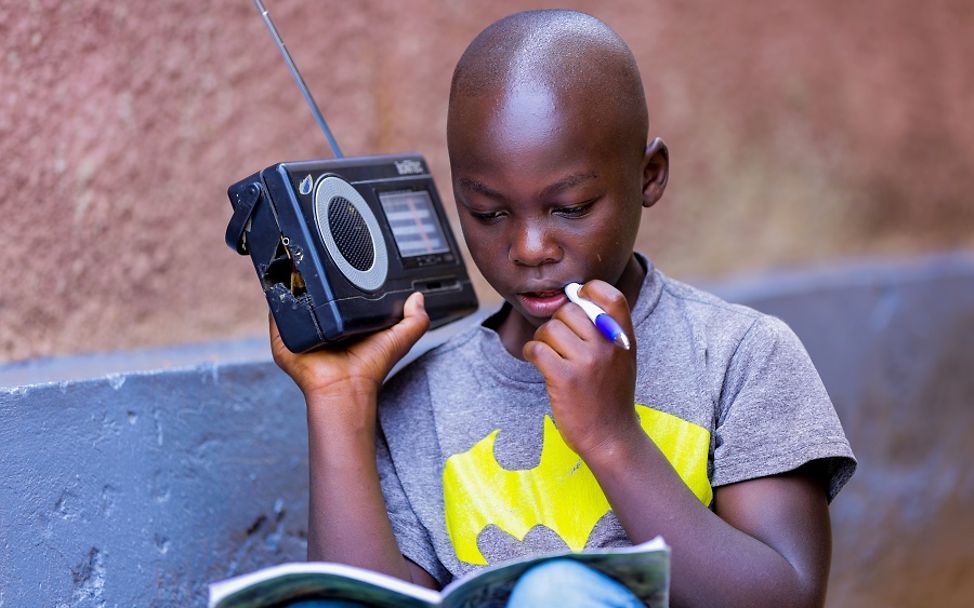 Ein Schüler aus Ruanda folgt gespannt der Unterrichtsstunde im Radio