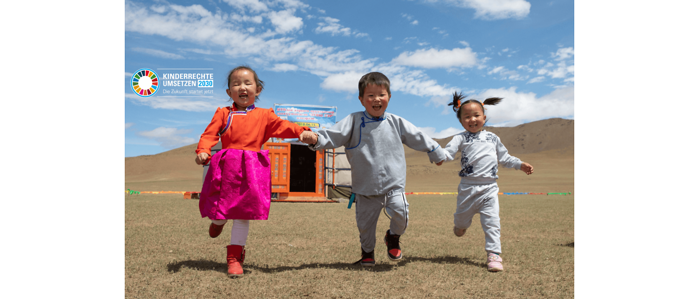 Neue Entwicklungsziele: Drei Kinder Hand in Hand in einem Tal.