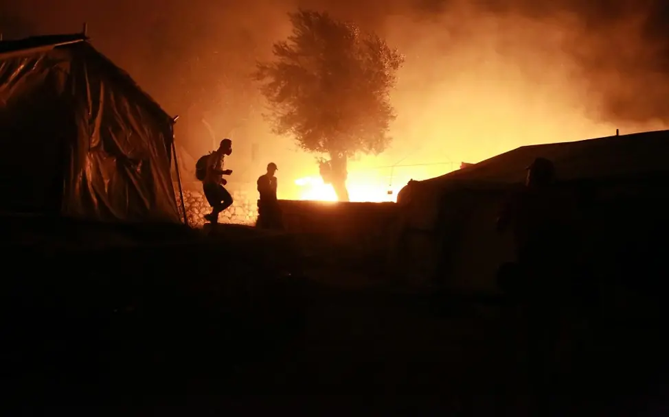 Feuer im Flüchtlingslager Moria | © UNICEF/Lagoutaris/AFP Feuer im Flüchtlingslager Moria: Umrisse von zwei Personen und einem Zelt vor den Flammen