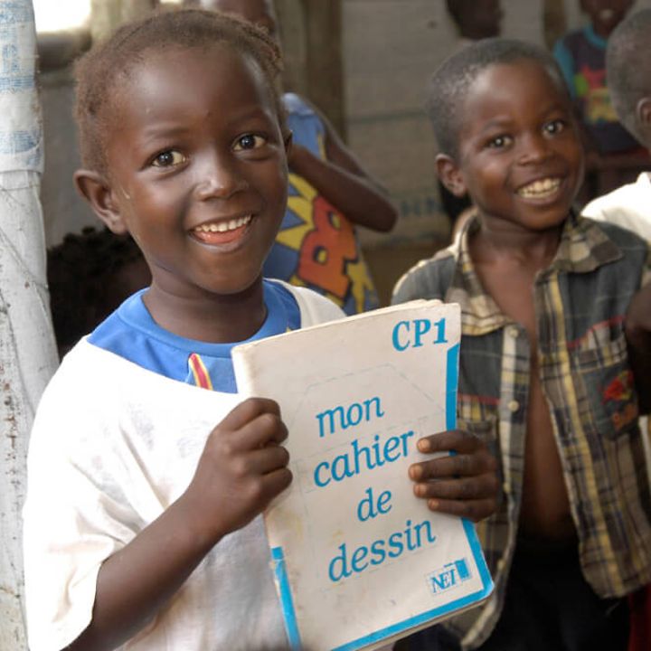 Liberia: Bildung für alle. Ein Schüler hält sein Schreibheft in der Hand. 