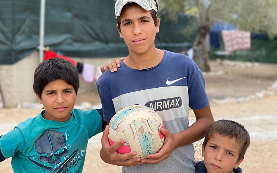 Moria: Yosif spielt mit zwei kleinen Jungs Fußball.