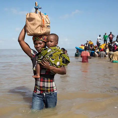 Idai Mosambik: Eine Frau trägt ein Kind durch Wasser | © UNICEF/Oatway Idai Mosambik: Eine Frau trägt ein Kind durch Wasser