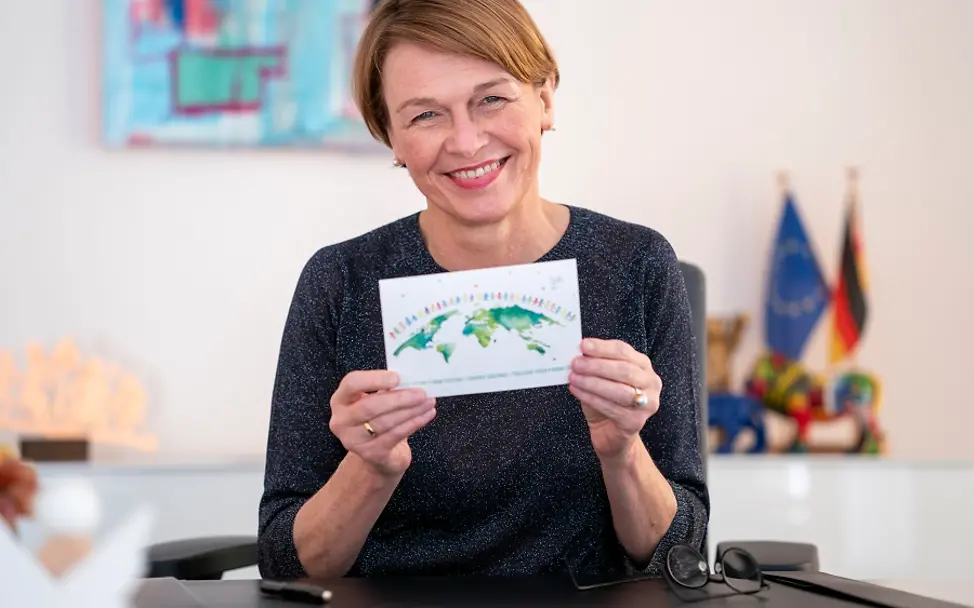 Elke Büdenbender ruft zum Schreiben von UNICEF-Karten auf| © Henning Schacht Elke Büdenbender präsentiert UNICEF-Karte in die Kamera.