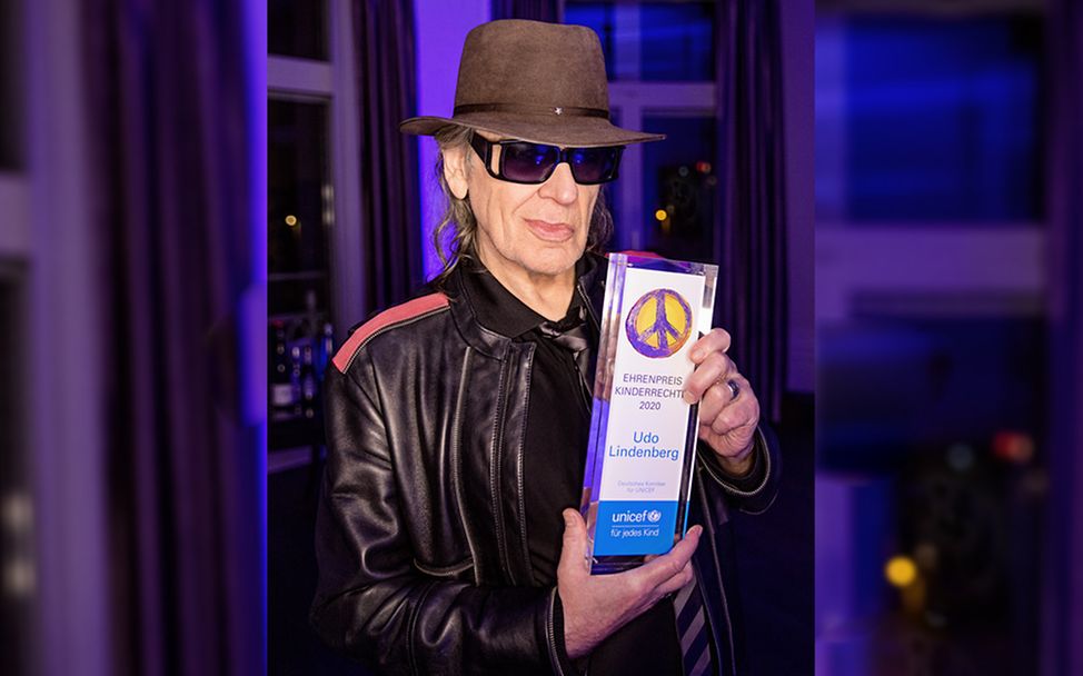 Rockstar Udo Lindenberg hält den UNICEF Ehrenpreis Kinderrechte in den Händen.