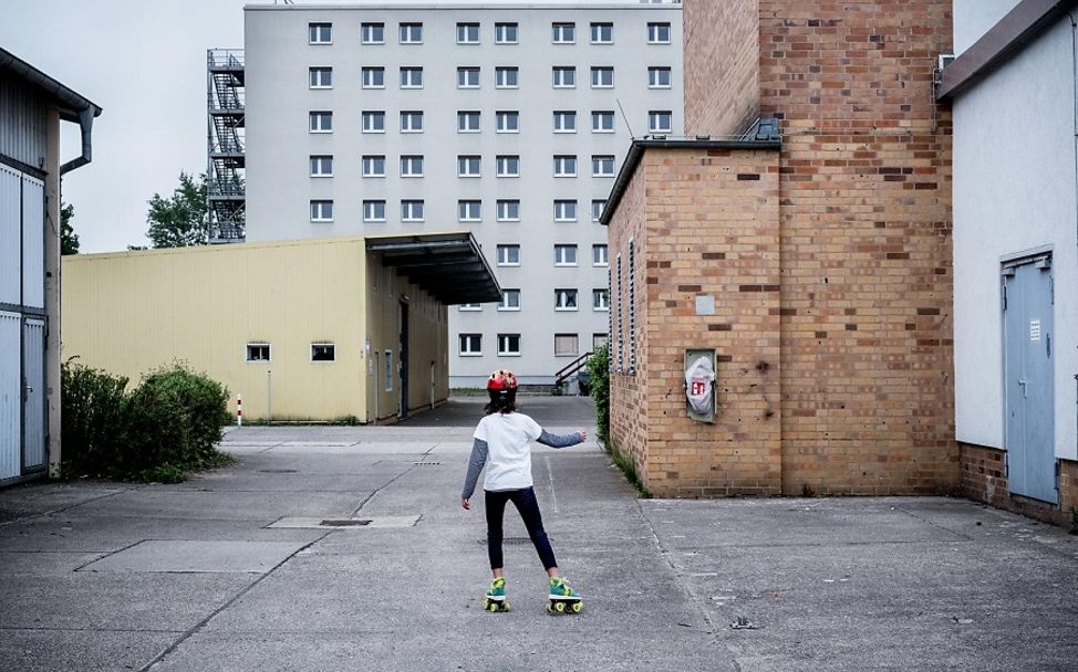 Flüchtlinge in Deutschland: Kind fährt in Innenhof Rollschuhe.