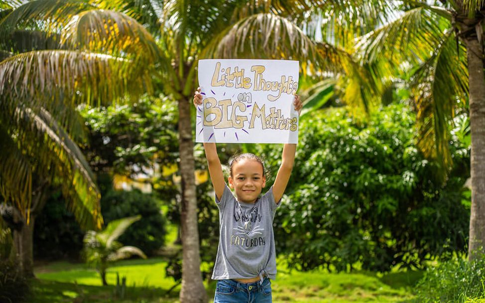 Barbados: Ein Mädchen hält ein Plakat in die Höhe.