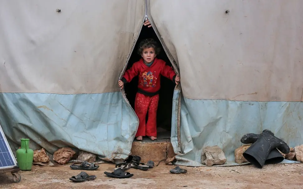 Syrien: 10 Jahre nach Kriegsbeginn muss die Gewalt endlich enden | © UNICEF/Akacha Syrien: Ein Kind schaut aus dem Zelt eines Flüchtlingscamp