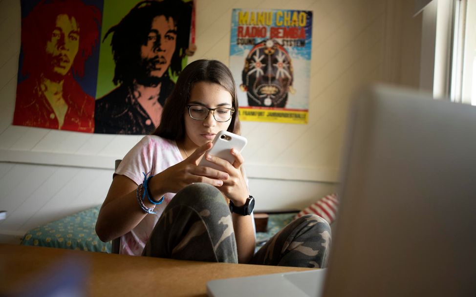 Lola (15) chatten während des Fernunterrichts.