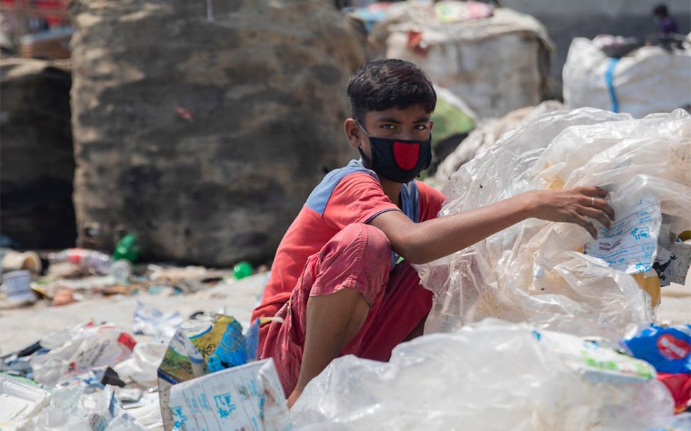 Bangladesh: Junge sortiert Müll um seine Familie zu helfen.