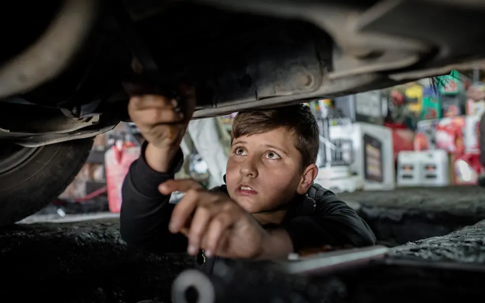 Der 14-jährige Mohammed repariert ein Auto. | © UNICEF/Yar Irak: Junge arbeitet in einer Autowerkstatt.