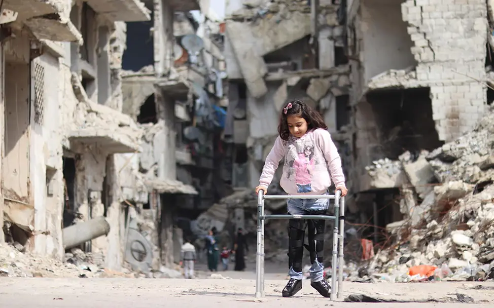 Rama aus Syrien läuft mit ihrer Gehhilfe durch Trümmer in Aleppo. | © UNICEF/Al-Issa Syrien: Rama läuft mit ihrer Gehhilfe durch Trümmer in Aleppo.