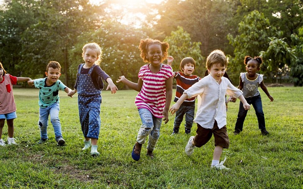 Bundestagswahl 2021: Kinder rennen lachend über eine Wiese