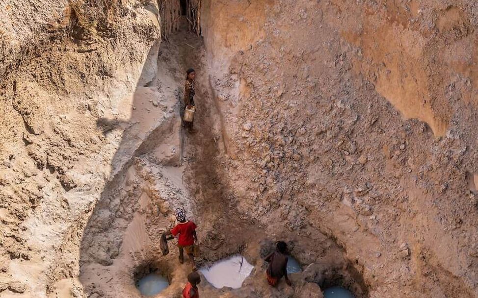 Menschen graben große Löcher um an Wasser zu gelangen.