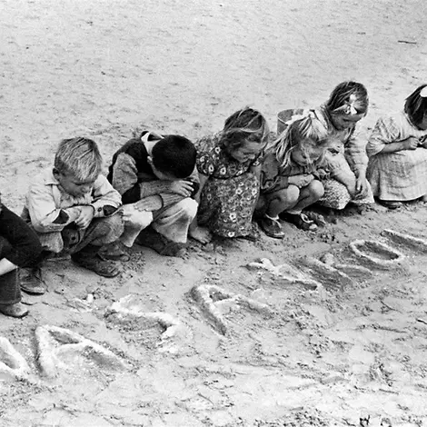 75 Jahre UNICEF-Hilfe: Ägypten | © UNICEF/Mihanoff 75 Jahre UNICEF: Jugoslawische geflüchtete Kinder schreiben in den Sand in Ägypten