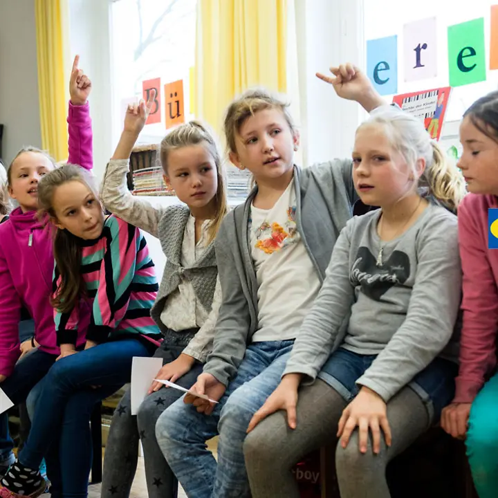 IKEA unterstützt UNICEF-Programm Kinderrechteschulen | © UNICEF/Etges IKEA Kinderrechte: Schülerinnen zeigen auf, um sich zu beteiligen.