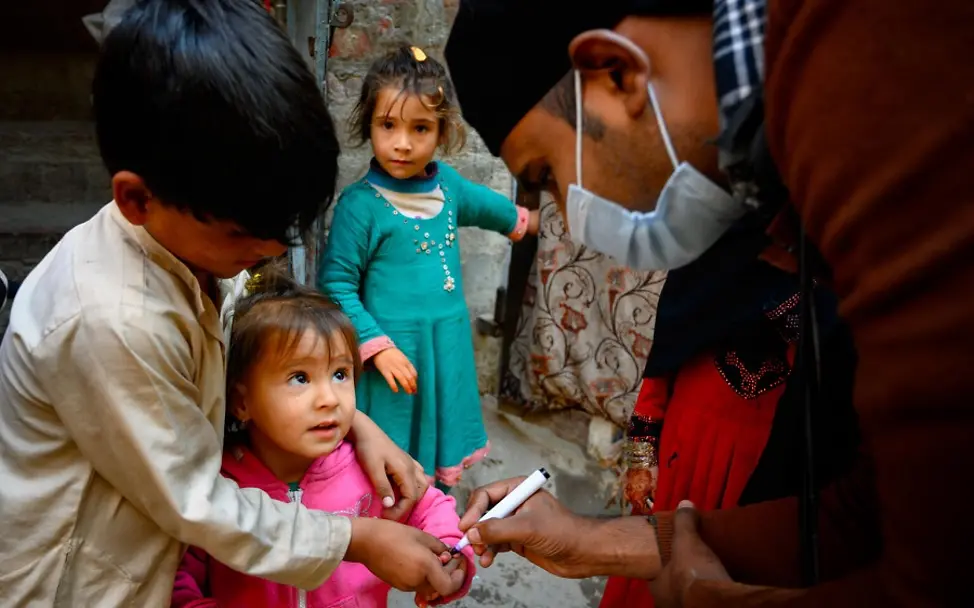 Impfungen muss Priorität eingeräumt werden | © UNICEF/Bukhari Subhan, ein Impf-Helfer, markiert den Finger eines kleinen Mädchens, das gerade geimpft wurde.