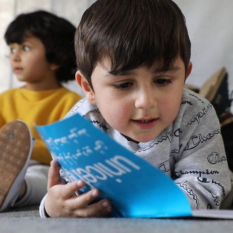 Afghanistan: Ahmad liest in einem UNICEF-Heft