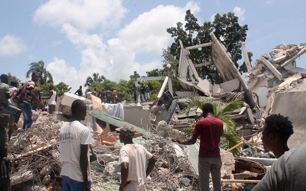 Erbeben Haiti Nothilfe: Menschen stehen nach dem Unglück vor den Überresten eines Hotels