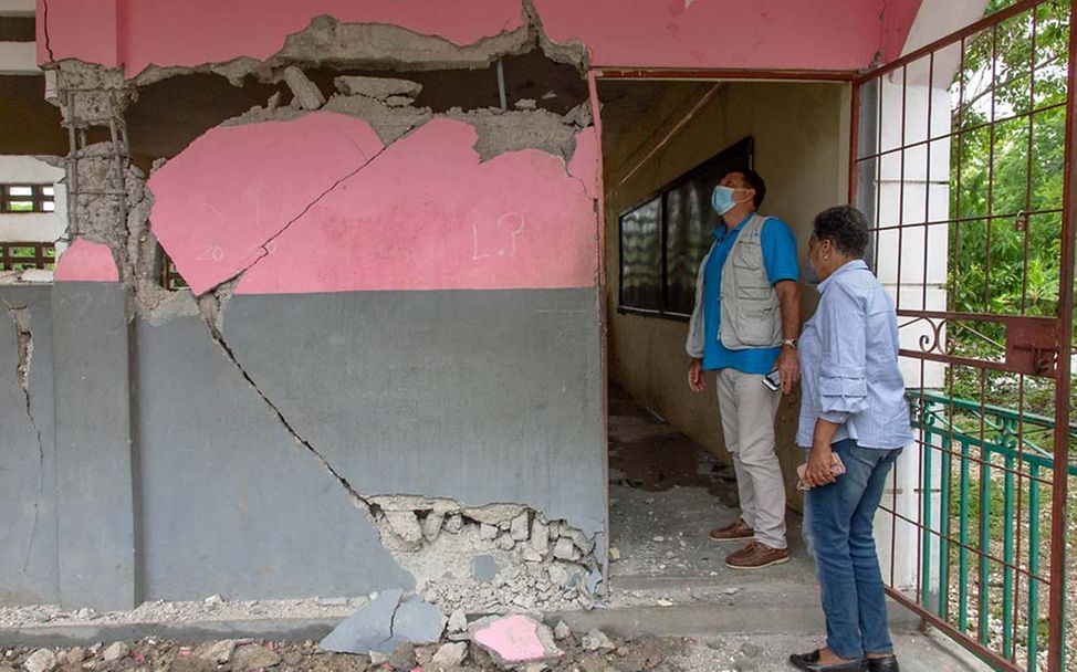 Haiti Erdbeben Nothilfe: UNICEF-Mitarbeiter sehen sich die Zerstörung an einer der beschädigten Schulen an.