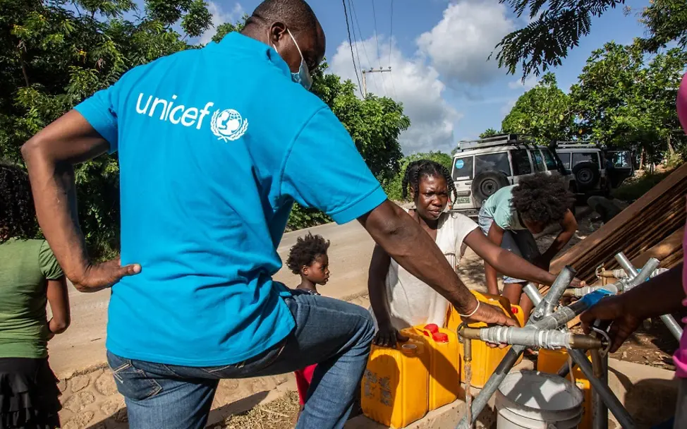 Erdbeben in Haiti: Kinder durch Krankheiten aus Wasser bedroht | © UNICEF/Rouzier UNICEF-Mitarbeiter stellt sauberes Wasser aus einer Pumpe bereit.