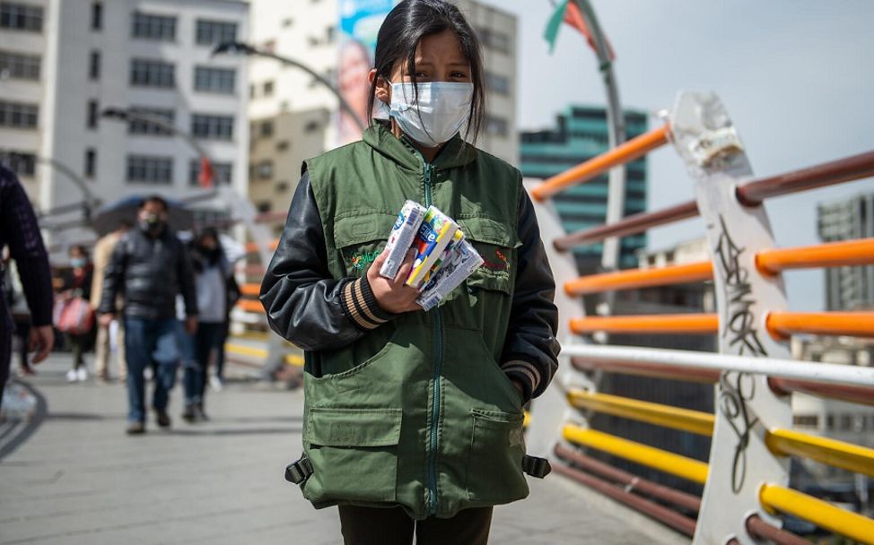 Valentinne (9) aus Bolivien verkauft jeden Morgen Taschentücher an Passanten.