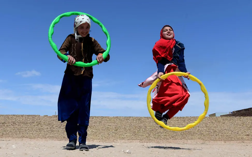 Afghanistan: Mädchen hüpfen unter blauem Himmel durch Reifen | © UNICEF/UNICEF Afghanistan Afghanistan Kinder: Mädchen hüpfen unter blauem Himmel durch Reifen