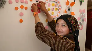 Afghanistan: Ein Mädchen hängt in einem UNICEF-Kinderzentrum etwas Gebasteltes auf | © UNICEF/UNICEF Afghanistan Afghanistan: Ein Mädchen hängt in einem UNICEF-Kinderzentrum etwas Gebasteltes auf