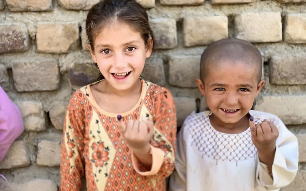 Afghanistan Kinder: Zwei Kinder zeigen nach der Polio-Impfung die Markierung an ihrem Finger | © UNICEF/Shah Afghanistan Kinder: Zwei Kinder zeigen nach der Polio-Impfung die Markierung an ihrem Finger